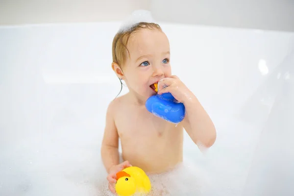 Baby girl in bath with fog havinf fun with duck — Stok fotoğraf