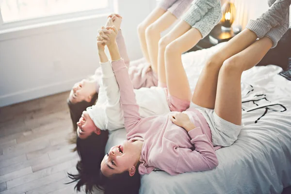 Three excited teenager girls having fun together enjoying laze leisure time on bed — Foto Stock