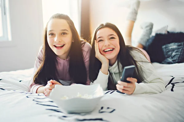 A pajama party with teens eat popcorn on the bed — Fotografia de Stock