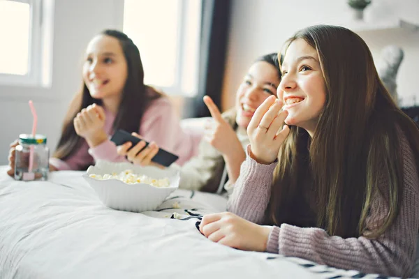 A pajama party with teens eat popcorn on the bed — Stok fotoğraf