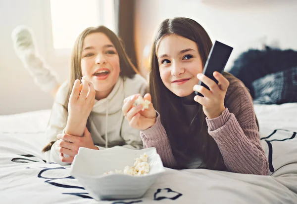A pajama party with teens eat popcorn on the bed — Fotografia de Stock