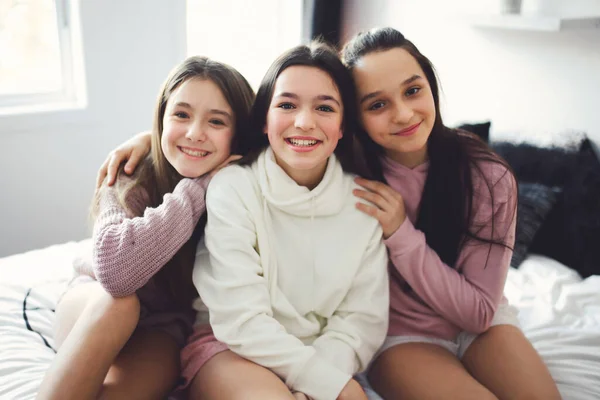 Three excited teenager girls having fun together, enjoying laze leisure time at home — Fotografia de Stock