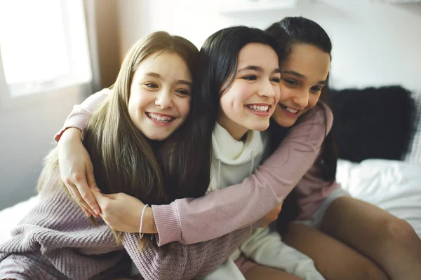 Three excited teenager girls having fun together, enjoying laze leisure time at home — Foto Stock