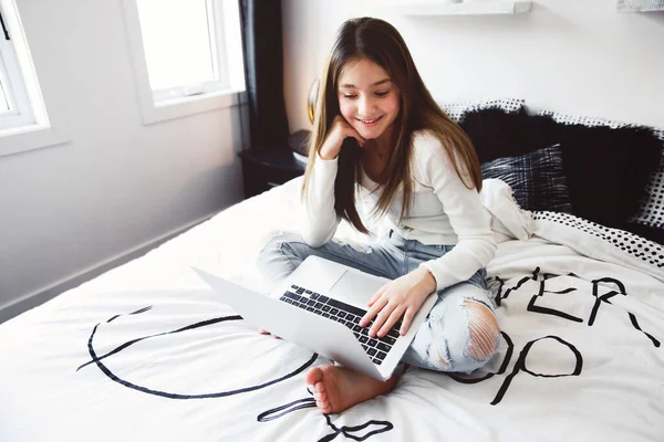 Гарна дівчина-підліток використовує комп'ютер у своїй спальні . — стокове фото