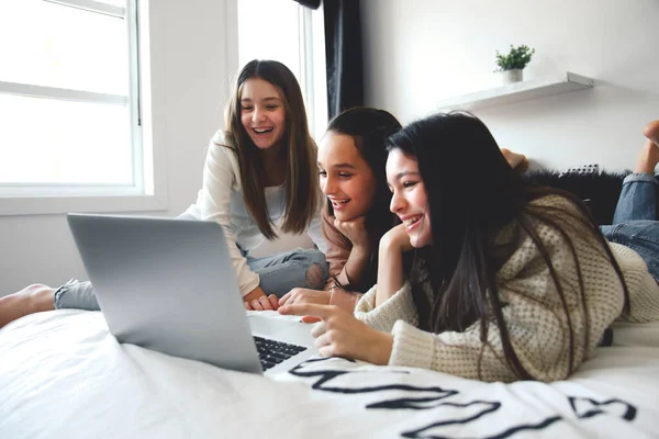 Teen friends using laptop on the bedroom — стоковое фото