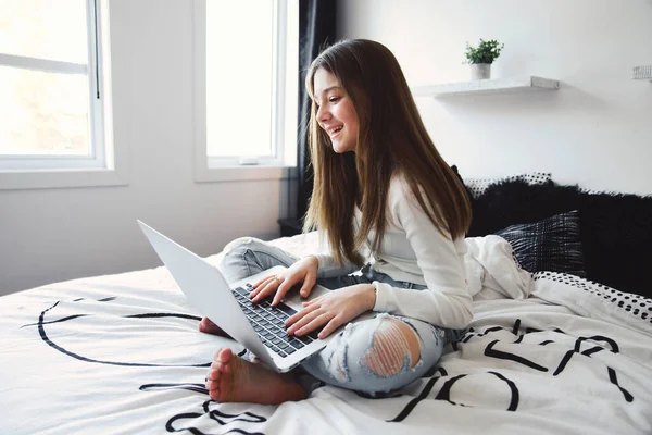 Belle adolescente utilisant un ordinateur dans sa chambre. — Photo