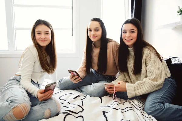 Grupo de adolescentes usando um celular no quarto em casa — Fotografia de Stock