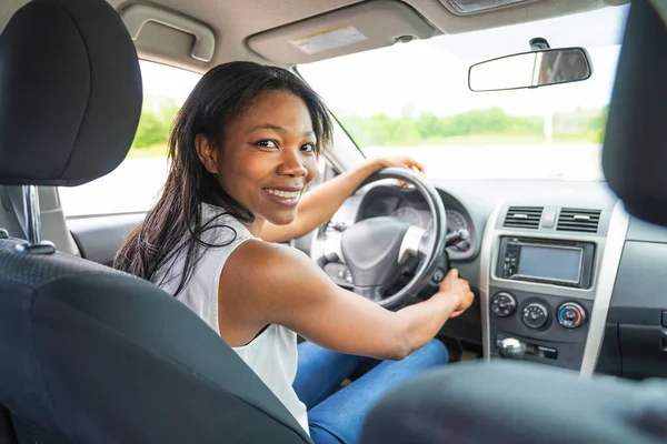 black woman driver seated in her new car