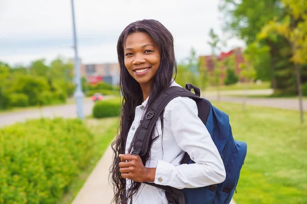 A black adult woman university student on campus with backpack — Stockfoto