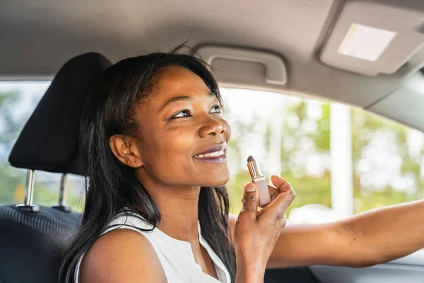 Black woman driver seated in her new car with lipstick — Photo