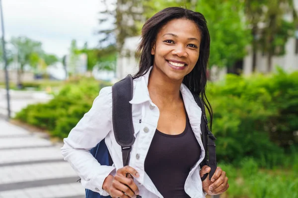 En svart vuxen kvinna universitetsstudent på campus med ryggsäck — Stockfoto