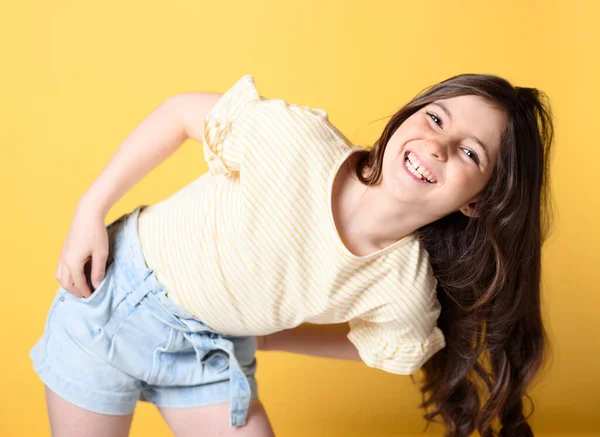 Cute child over yellow background on studio — ストック写真