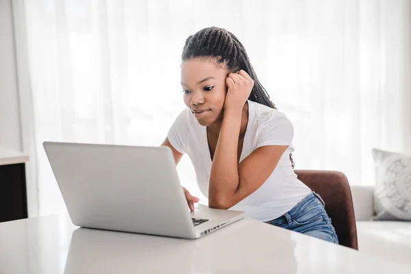Κορίτσι του σχολείου κάθεται στο σπίτι με φορητό υπολογιστή — Φωτογραφία Αρχείου