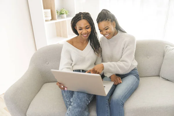 Mère et fille assis sur le canapé à la maison avec ordinateur portable — Photo