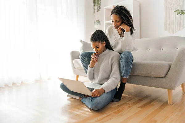 Mère et fille assis sur le canapé à la maison avec ordinateur portable — Photo
