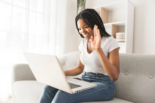 Jeune afro-américaine adolescent sur un canapé dans son salon parler avec quelqu'un sur un ordinateur portable — Photo