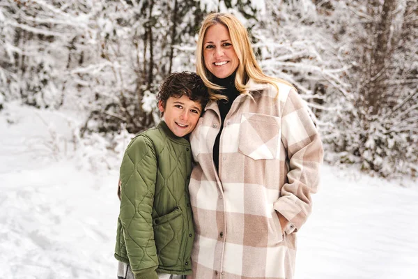Мальчик и мать в лесу в зимний сезон — стоковое фото