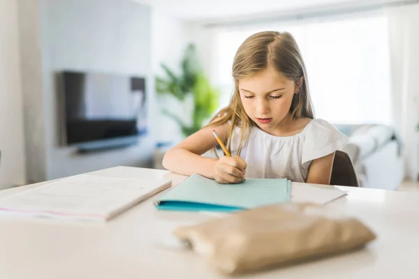 Досить маленька дівчинка любить вчитися і робити домашнє завдання — стокове фото
