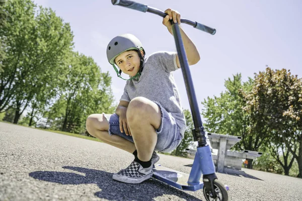 Portrait of young boy with scooter on park — стоковое фото