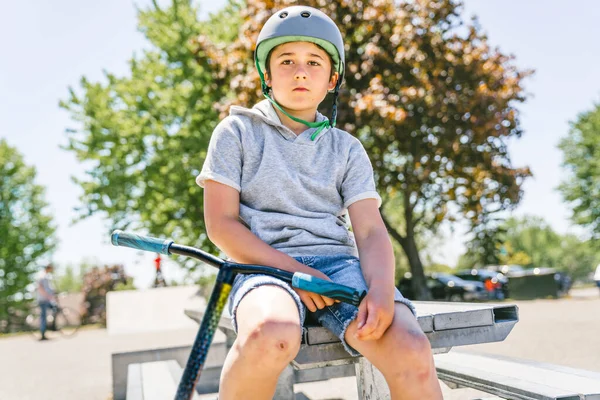 Portrait of young boy with scooter on park — Foto Stock