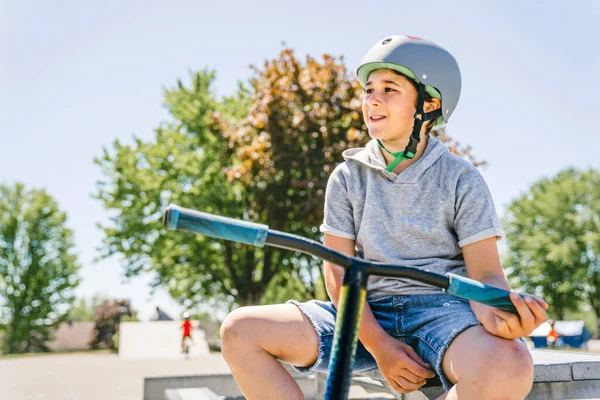 Portrait de jeune garçon avec scooter sur le parc — Photo