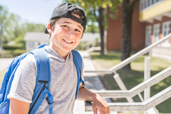 Niño pequeño en el patio de la escuela con mochila — Foto de Stock