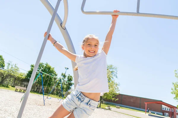 Petite fille active s'amusant sur l'aire de jeux à l'heure d'été — Photo