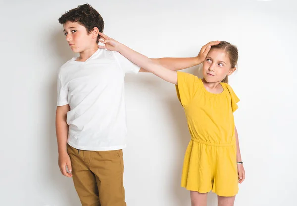 Portrait of cute girl and boy on studio white background conflit each other — Stock Fotó