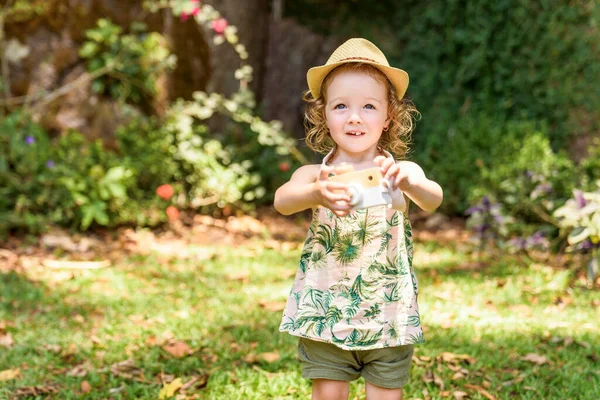 Two years child girl with hat and camera on forest — Stock fotografie