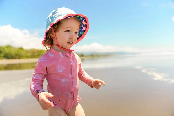 Malá rozkošná dívka 2 roky radostně na pláži při západu slunce na dovolené — Stock fotografie