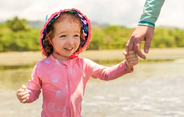 Liten bedårande flicka 2 år glatt på stranden i solnedgången på semester — Stockfoto
