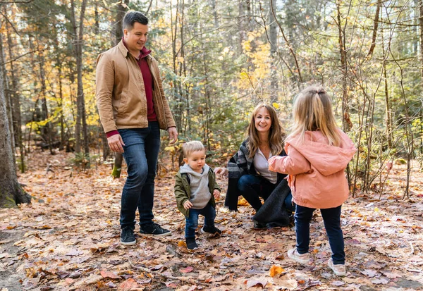 Aile sonbahar ormanında eğleniyor. — Stok fotoğraf
