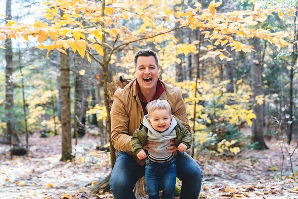 Son and her father in the autumn season in park — стоковое фото