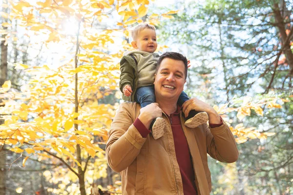Oğlu ve babası sonbahar mevsiminde parkta çocuk kucağındaydılar. — Stok fotoğraf
