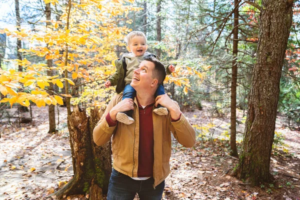 Oğlu ve babası sonbahar mevsiminde parkta çocuk kucağındaydılar. — Stok fotoğraf