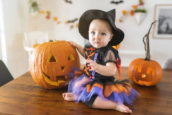 Krásná holčička v čarodějnice halloween kostým doma kuchyně stůl — Stock fotografie