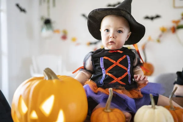 美しいです赤ちゃん女の子で魔女ハロウィン衣装でホームキッチンテーブル — ストック写真
