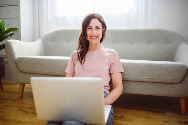 Vrouw ontspannen thuis op bank, genieten van vrije tijd met laptop op de bank — Stockfoto