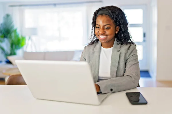 Portrait of a beautiful young woman with laptop and cellphone at home — Fotografia de Stock