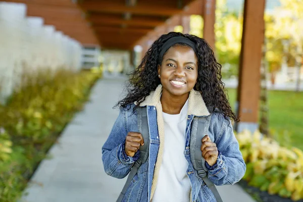 Pretty african american woman with backpack at the park — Stockfoto