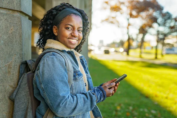 Outdoor portrait of a Young black African American young woman on mobile phone — Stockfoto