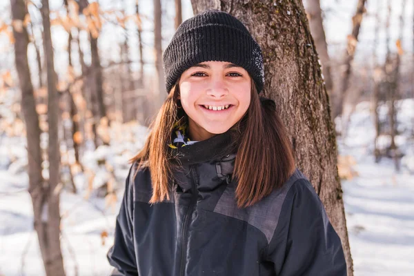 Portrait of happy little girl in winter forest — Stock fotografie
