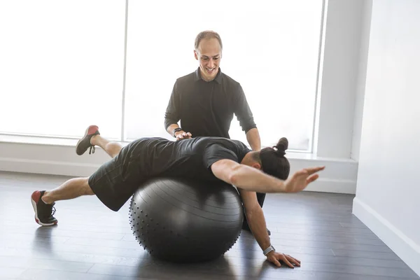 Physiotherapist doing therapeutic exercises for patient at the clinic. — Stock Fotó