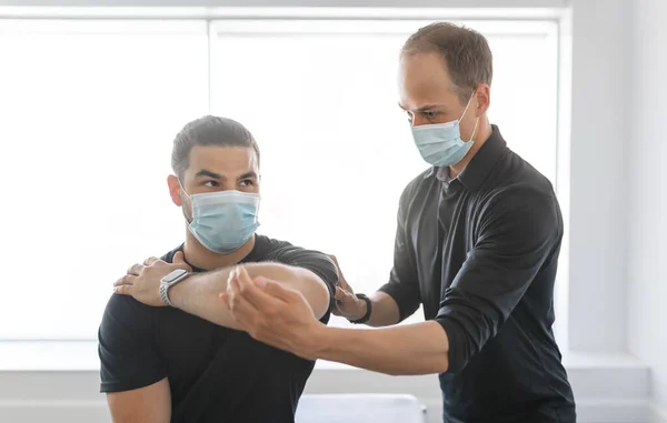 Physiotherapist doing therapeutic exercises for patient at the clinic. — Stockfoto