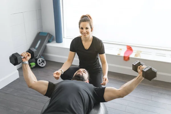 Trainer en client bespreken haar vooruitgang in de sportschool — Stockfoto