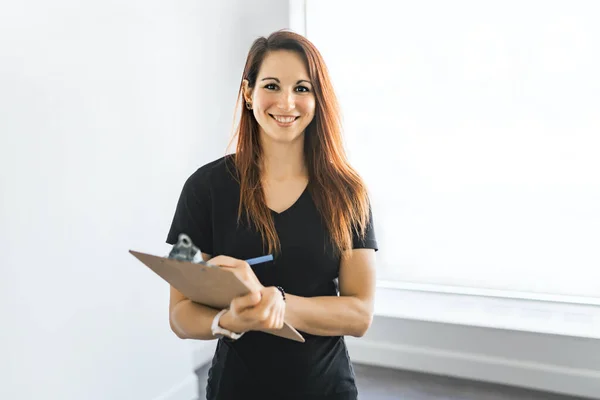 Female trainer standing with a smile in the training gym — Stock Photo, Image