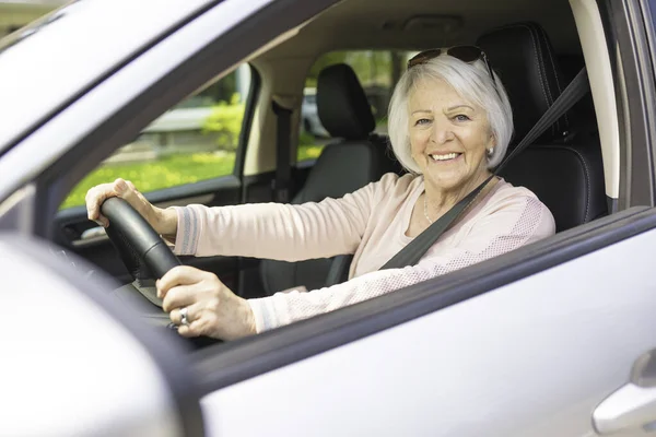 Glad och leende äldre kvinna i vit bil — Stockfoto
