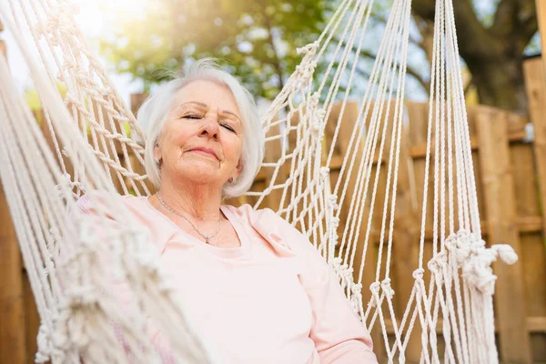 The senior woman relaxing in a hammock — Stok fotoğraf