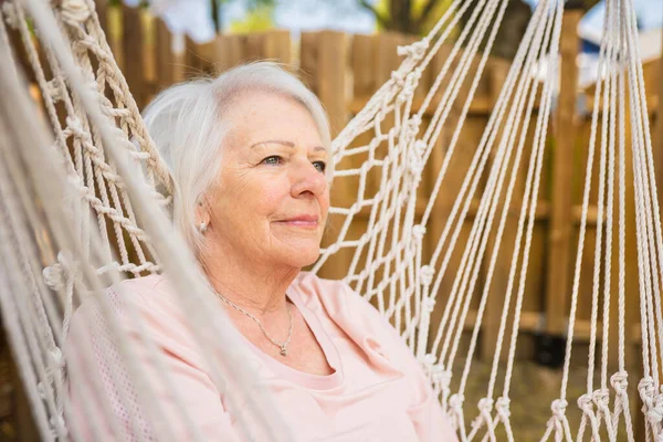 The senior woman relaxing in a hammock — стоковое фото
