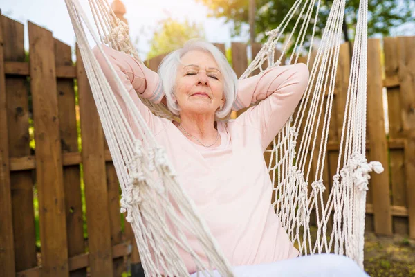 The senior woman relaxing in a hammock — Stok fotoğraf